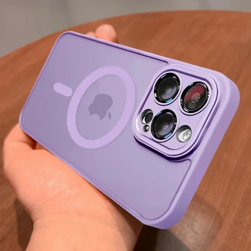 A light purple protective phone case with a MagSafe ring and camera cutout, held in a hand over a wooden surface.
