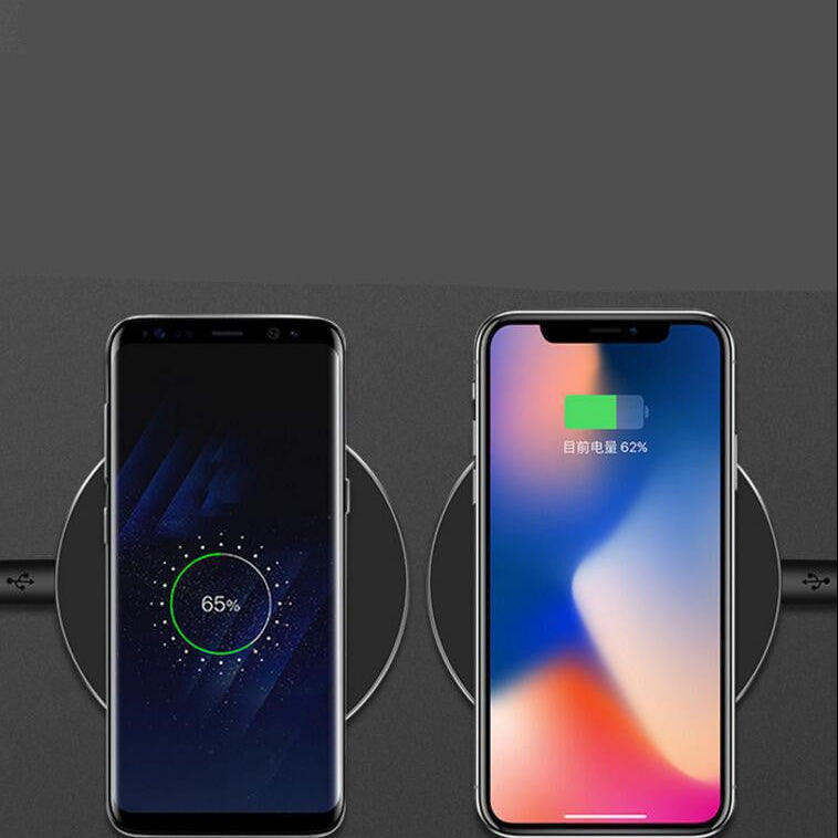 Two smartphones on wireless charging pads with battery percentage displayed.