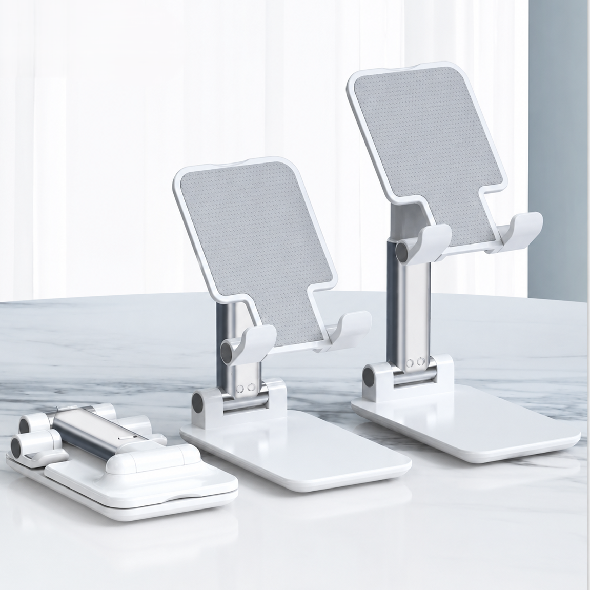 White adjustable phone stands with a mesh back panel, shown alongside a matching white charging cable on a clean white and light gray surface.