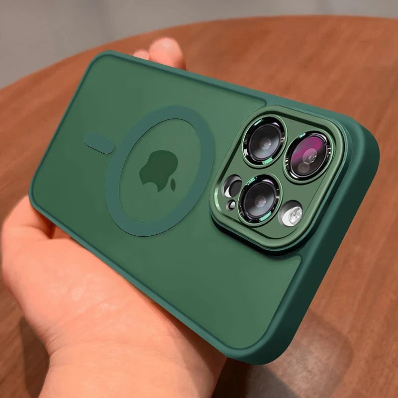 An alphine green protective phone case with a MagSafe ring and camera cutout, held in a hand over a wooden surface.