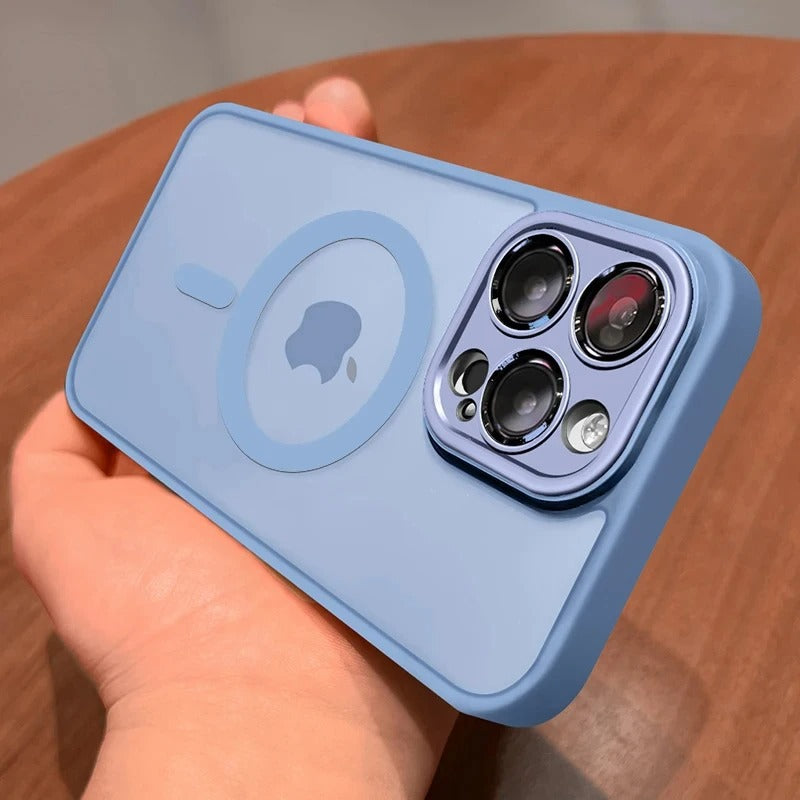 A sierra blue protective phone case with a MagSafe ring and camera cutout, held in a hand over a wooden surface.