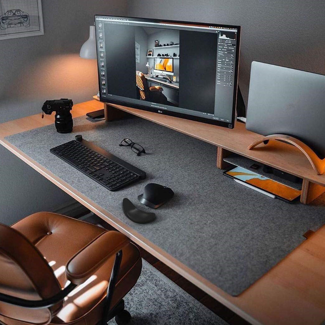 Modern office desk setup with computer monitor, keyboard, mouse, and camera.